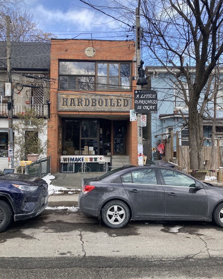 Small brick shop with a hand-painted sign on a city street